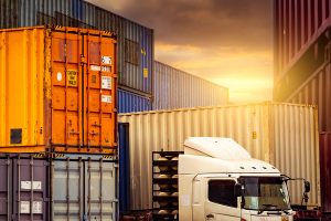 shipping dock with containers and truck to represent How Using an ERP in Manufacturing Supports Supply Chain Sovereignty